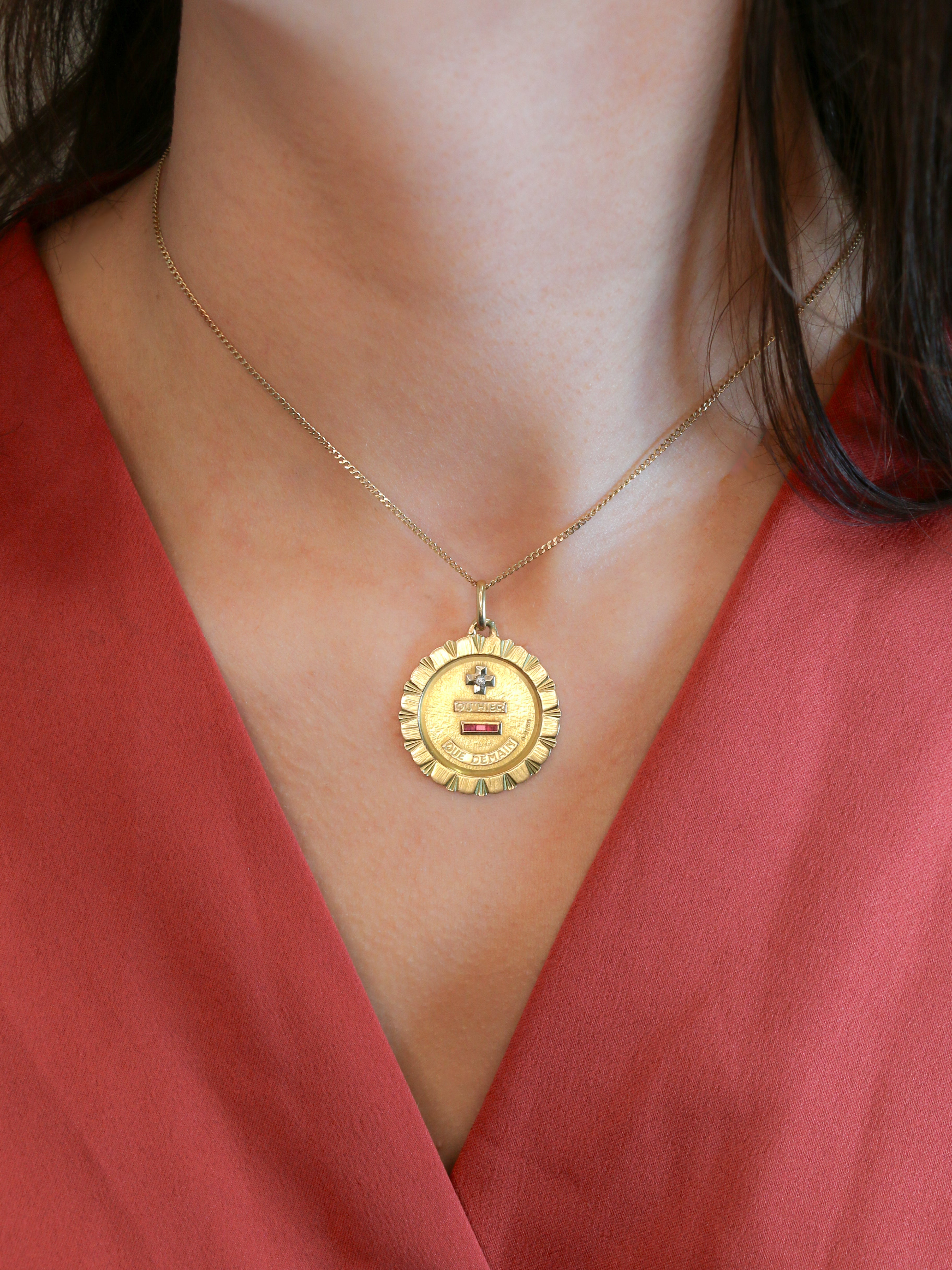 Médaille Amour Augis vintage Jumbo Plus hier moins demain or jaune diamant rubis
Médaille Amour en or jaune 18k (750°/°°). La célèbre mention Plus qu’hier Moins que demain, inspirée des vers de Rosemonde Gérard Rostand, est inscrite sur la médaille. La médaille est très importante et la typographie (barre du Q vers la gauche) ainsi que l'entourage en stries sont très rares et recherchés. Travail français de la première moitié du XXe siècle signé A.Augis. Présence du poinçon tête d’aigle et du poinçon de f