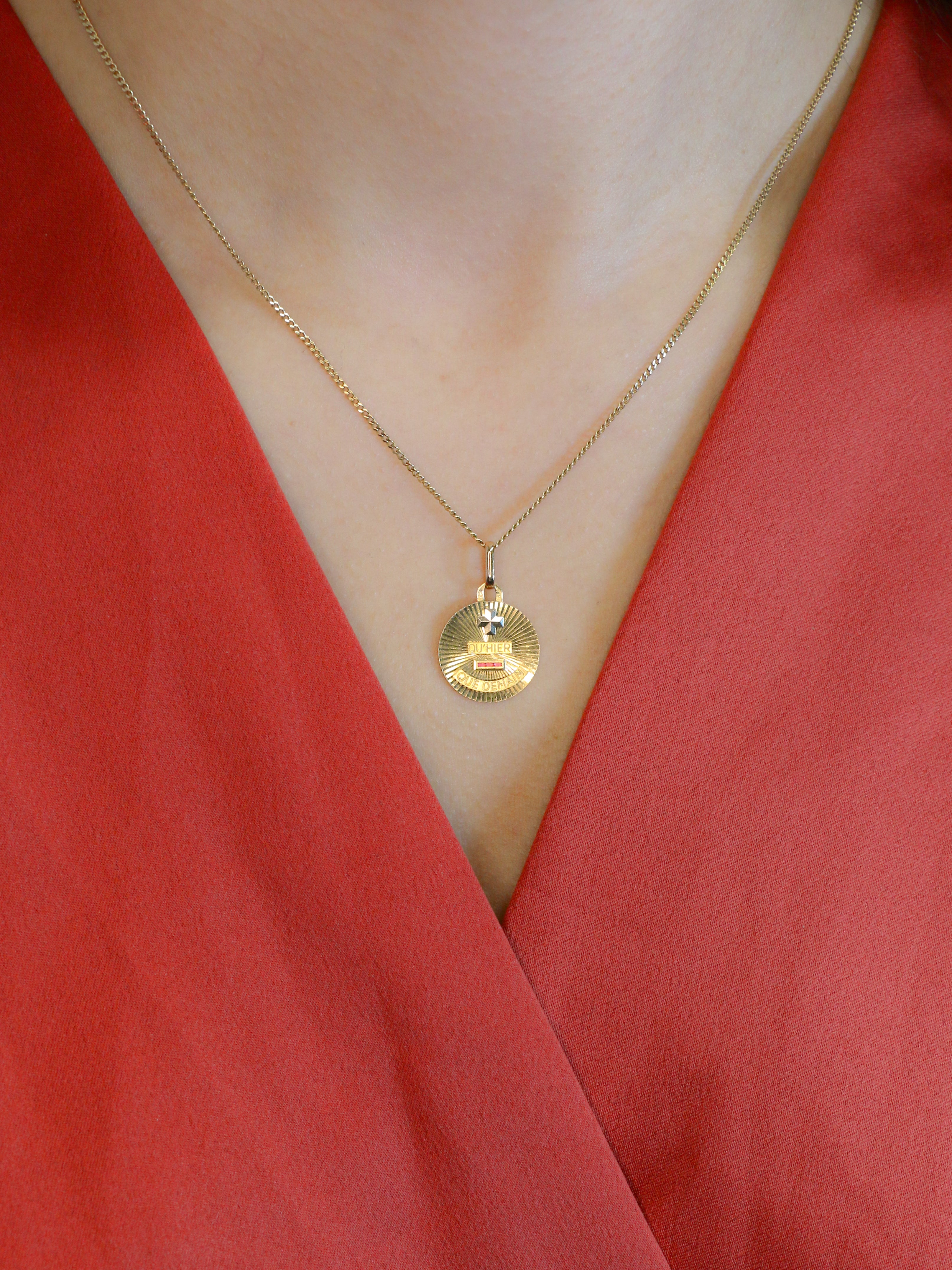 Médaille amour Augis vintage ronde rayonnante Plus hier moins demain
Médaille Amour en or jaune 18k (750°/°°) sertie de trois rubis synthétiques. La médaille est décorée d'un motif rayonnant caractéristique des productions de la Maison AUGIS des années 1970. Ce modèle n'est plus disponible à la vente aujourd'hui. La célèbre mention Plus qu’hier Moins que demain, inspirée des vers de Rosemonde Gérard Rostand, est inscrite sur la médaille. Travail français des années 1970, signé Augis. Présence du poin