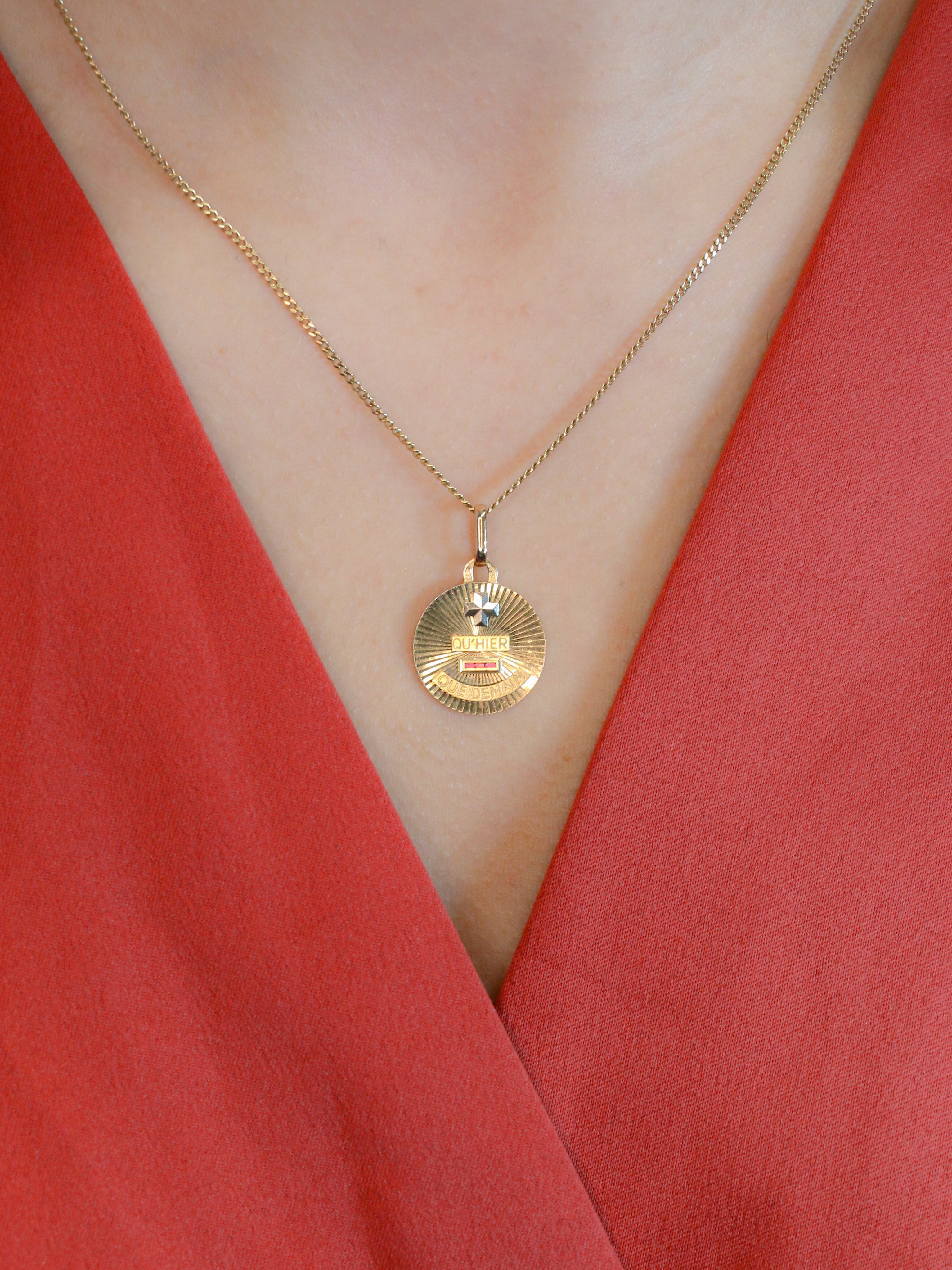 Médaille amour Augis vintage ronde rayonnante Plus hier moins demain
Médaille Amour en or jaune 18k (750°/°°) sertie de trois rubis synthétiques. La médaille est décorée d'un motif rayonnant caractéristique des productions de la Maison AUGIS des années 1970. Ce modèle n'est plus disponible à la vente aujourd'hui. La célèbre mention Plus qu’hier Moins que demain, inspirée des vers de Rosemonde Gérard Rostand, est inscrite sur la médaille. Travail français des années 1970, signé Augis. Présence du poin