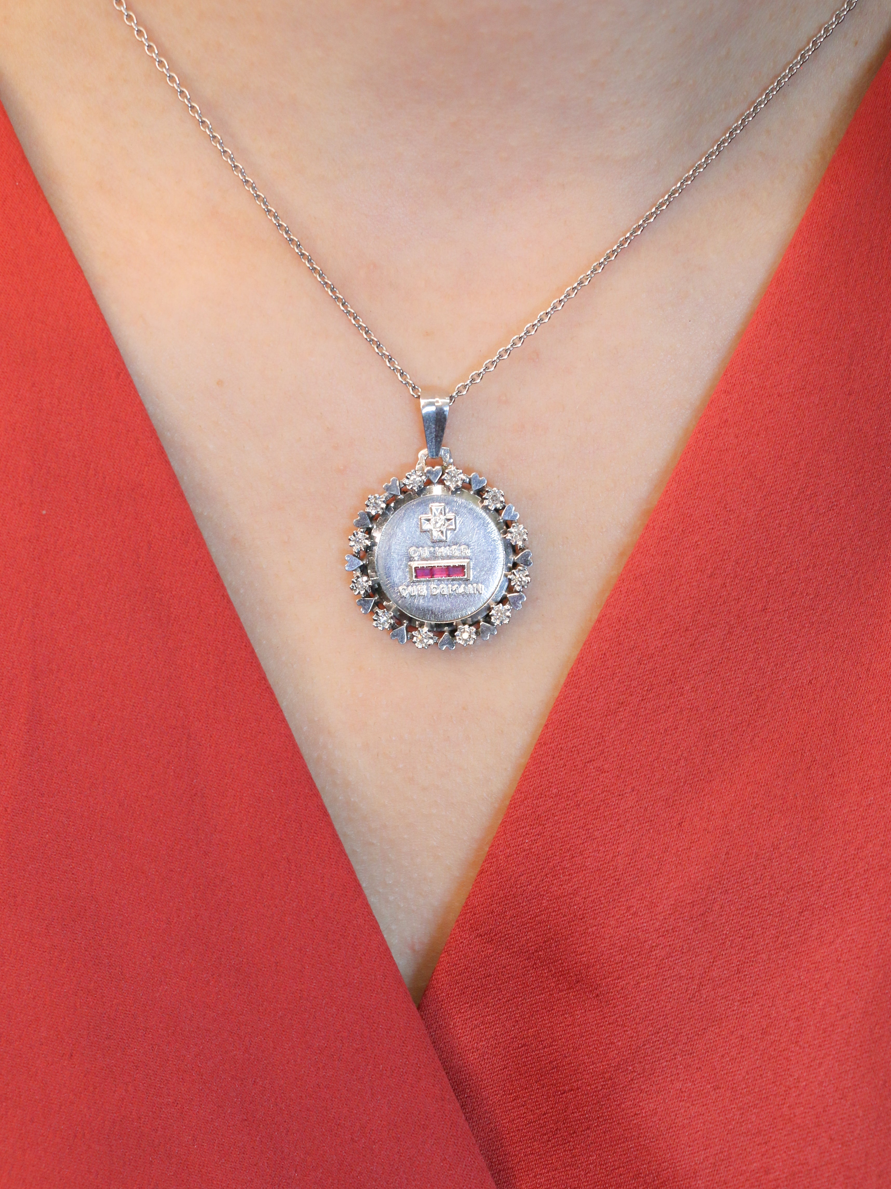 Médaille amour Augis vintage entourage coeur diamant Plus hier moins demain
Médaille amour Augis en or 18k (750°/°°) sertie de trois rubis synthétiques et d'un diamant taille 8x8 dans un entourage rayonnant. La médaille est inscrite dans un entourage composée d'une alternance de coeur et de diamants taille 8/8. La célèbre mention "Plus qu'hier moins que demain" inspirée des vers de Rosemonde Gérard Rostand est inscrite sur la médaille. Travail français vintage. Poinçon tête d'aigle et poinçon de A. A