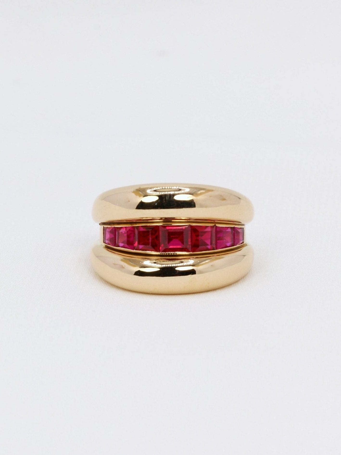 Bague jonc or jaune rubis
Bague en or 18k (750°/°°) composée de deux joncs liés par une ligne de rubis synthétiques calibrés. Traces de mise à taille et quelques chocs sur la partie basse de l’anneau. Travail probablement français des années 1960.
Tour de doigt 52
Poids brut : 10,80 grammes
