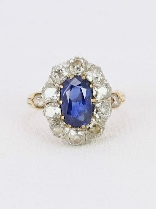Bague marguerite en or rose 18k (750°/°°) sertie en son centre d'un saphir coussin allongé Ceylan bleu intense non chauffé pesant 1,72 carats (8.91x5,64x3,47mm) dans un entourage de diamants taille ancienne pour un poids total d'environ 1,5 carats de qualité GH SI. Travail probablement français de la fin du 19ème siècle. 