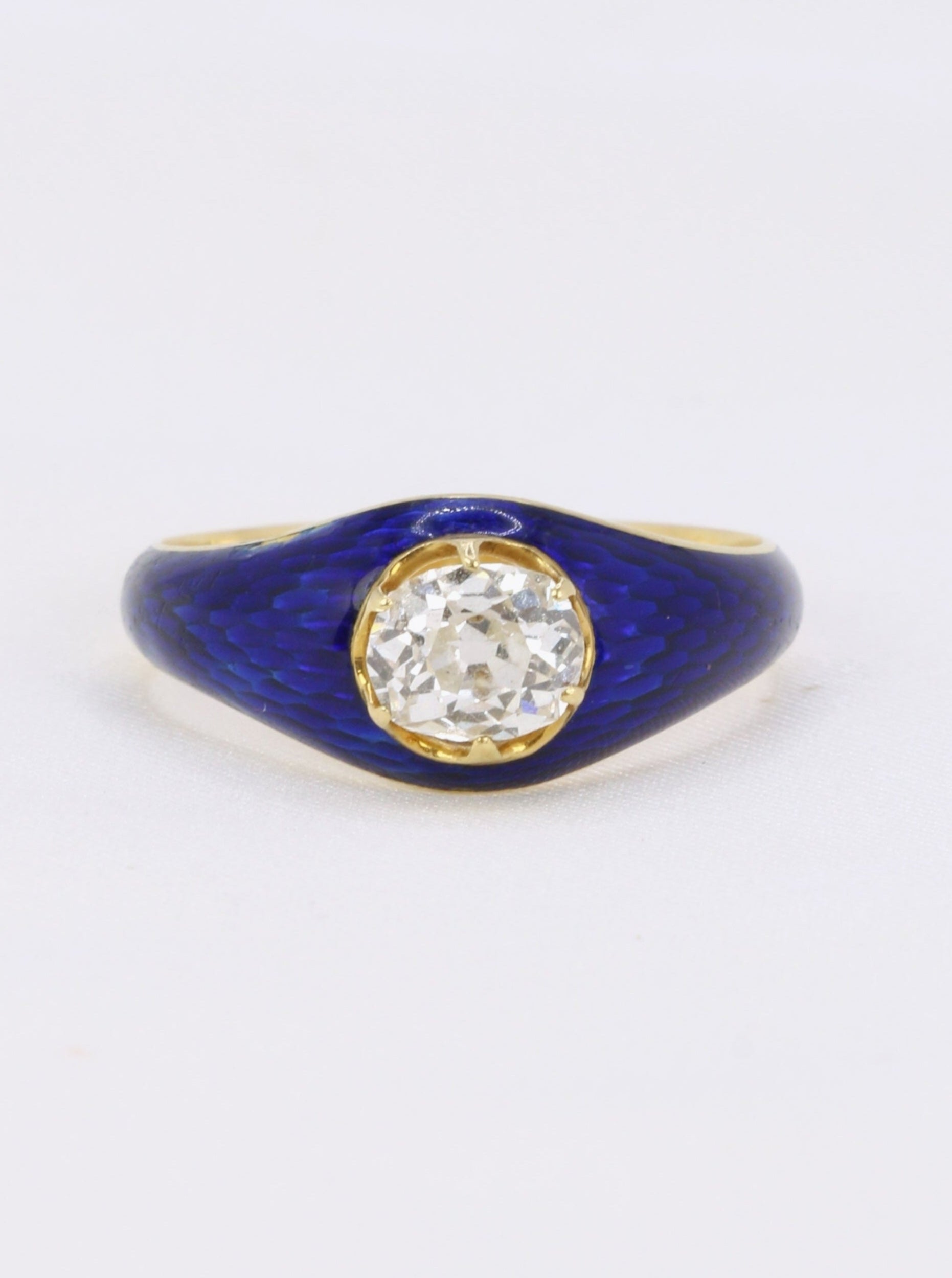 Bague solitaire en or 18k (750°/°°) sertie d’un diamant taille ancienne “old mine cut” calibrant 0.9 carats environ de qualité estimée HI SI2 (pas d'inclusion visible à l'oeil nu), l’anneau est rehaussé d'émail bleu nuit. Travail français ou anglais de la seconde partie du XIXe siècle. A noter un léger saut d'émail visible sur photos.