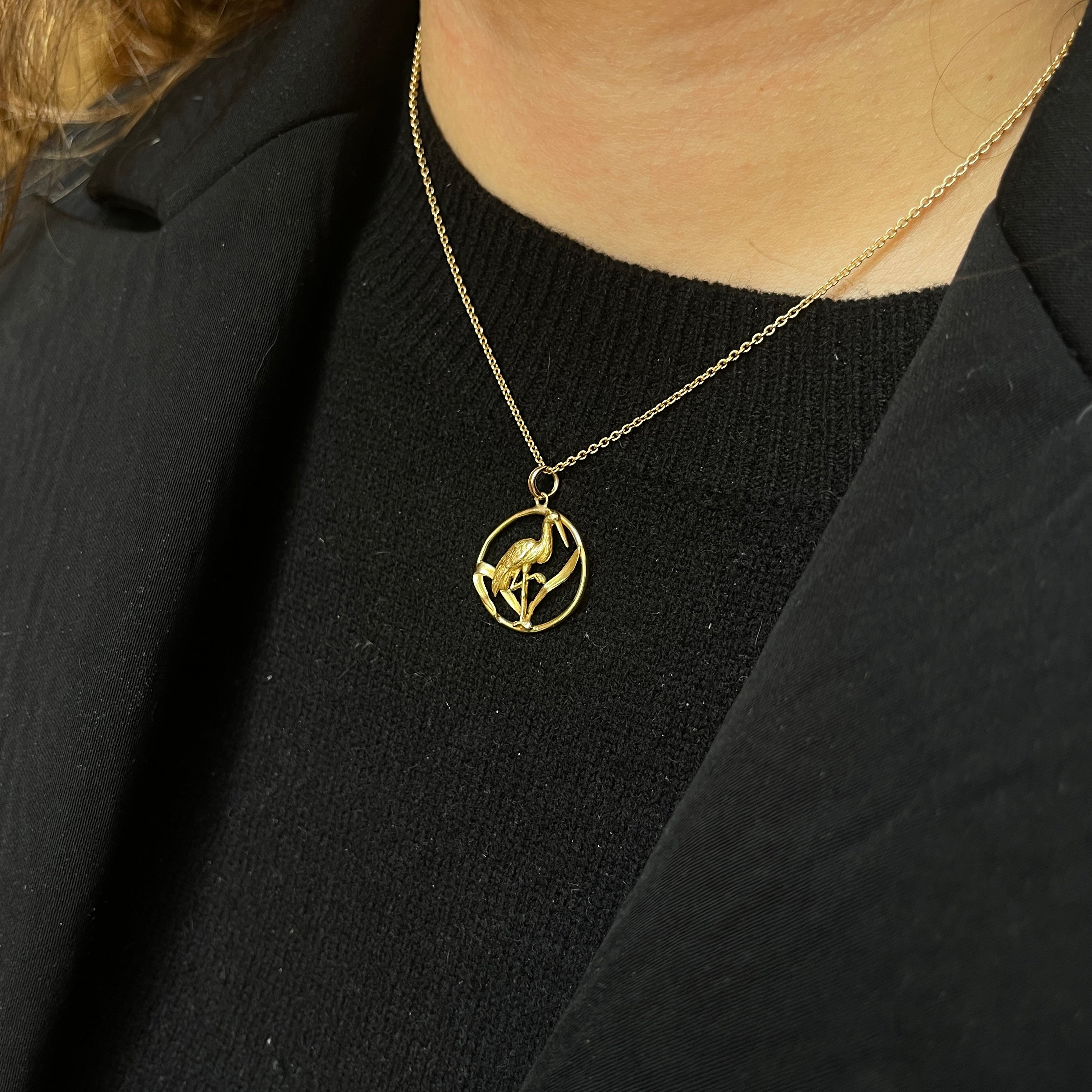 Old gold pendant depicting a stork