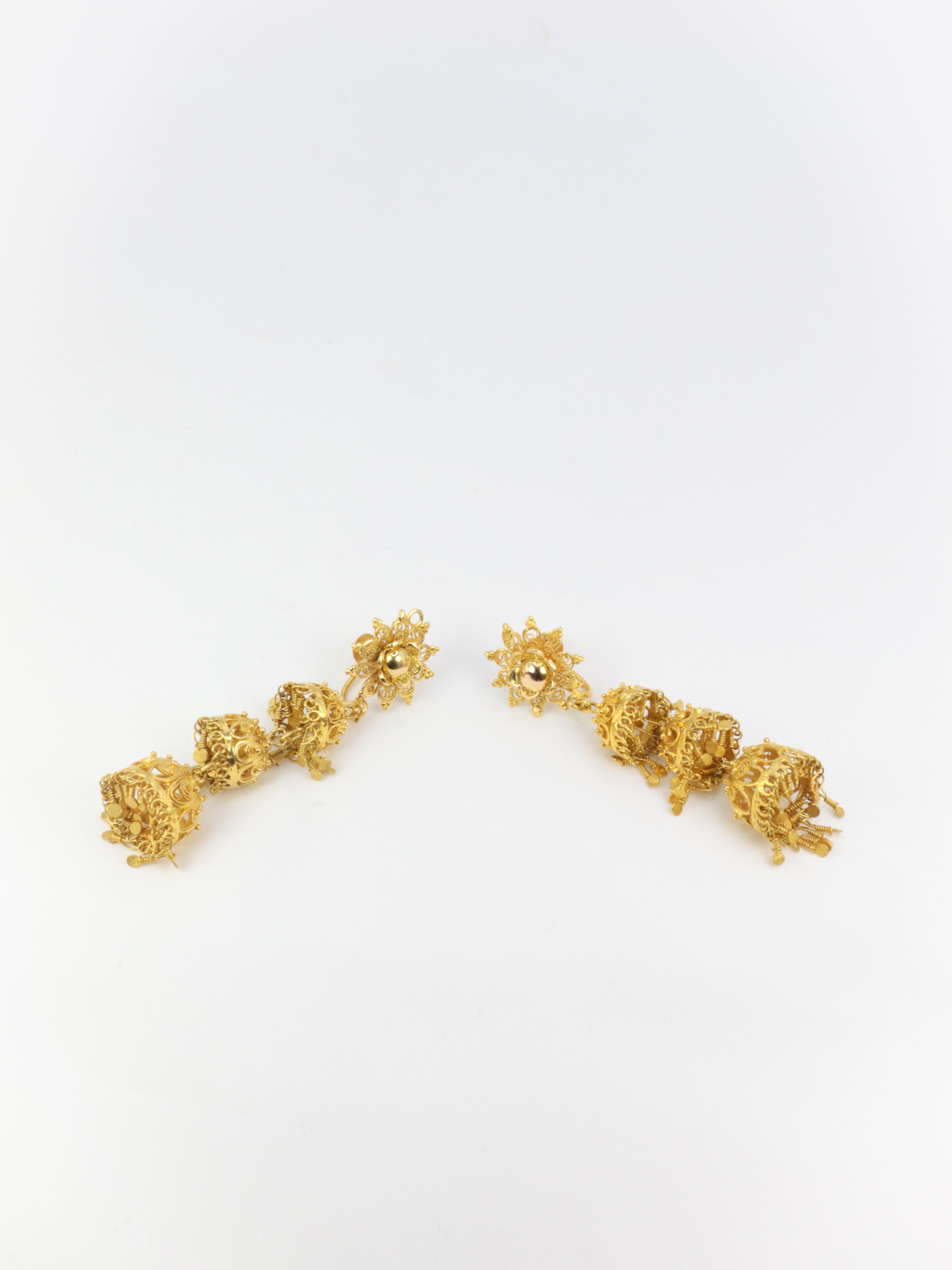 Old earrings composed of arabesques and gold tassels
