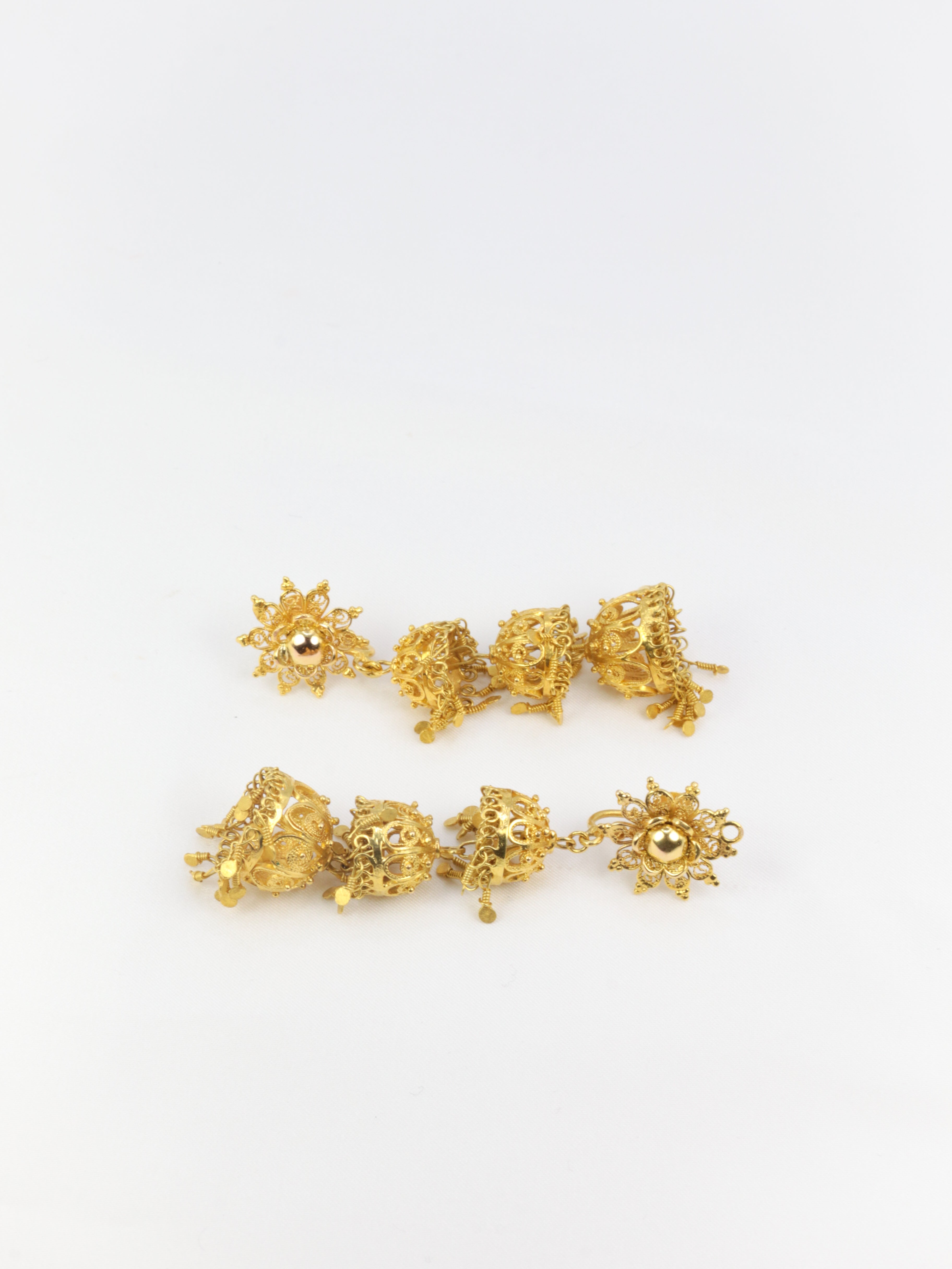 Old earrings composed of arabesques and gold tassels