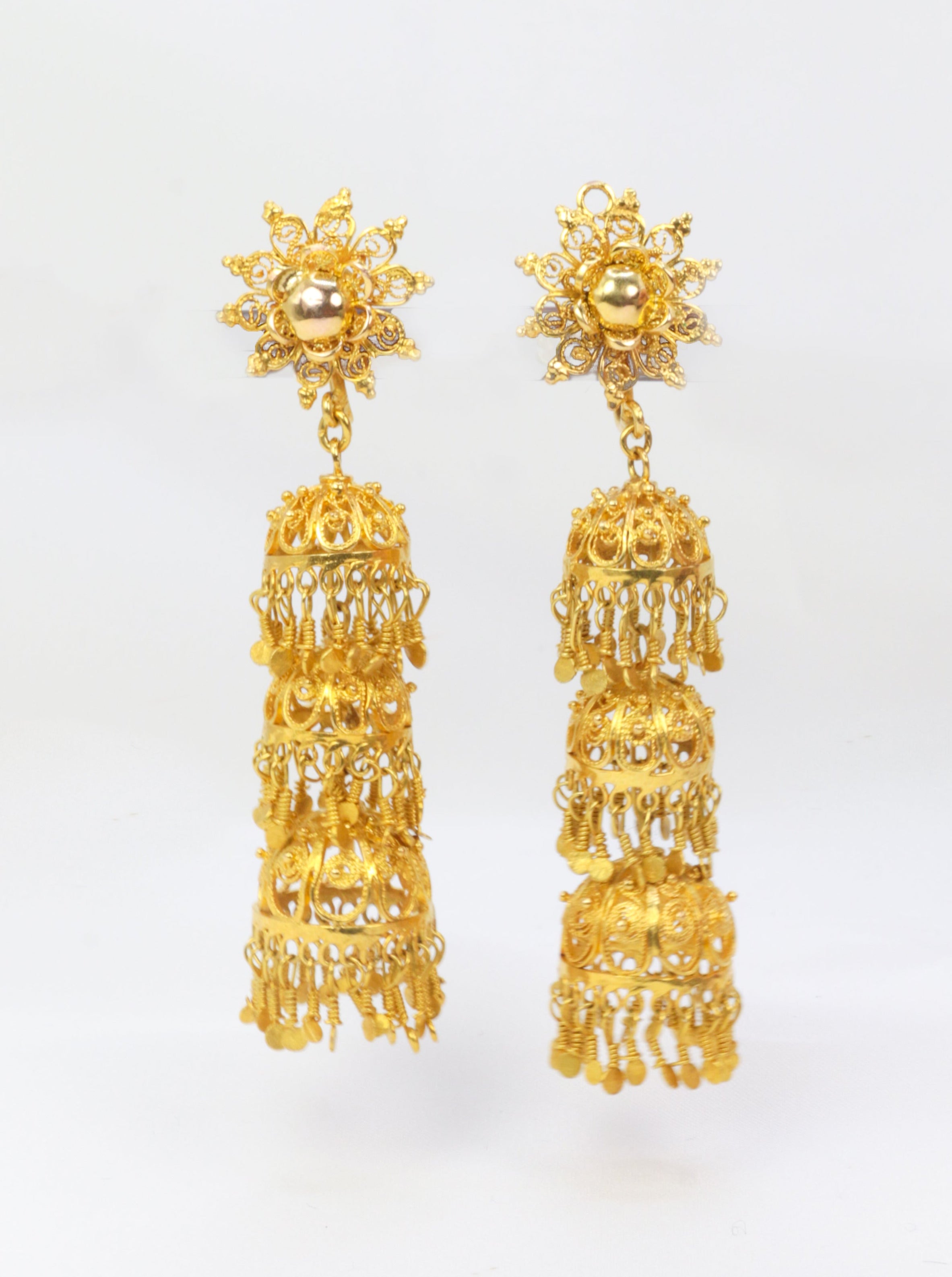Old earrings composed of arabesques and gold tassels