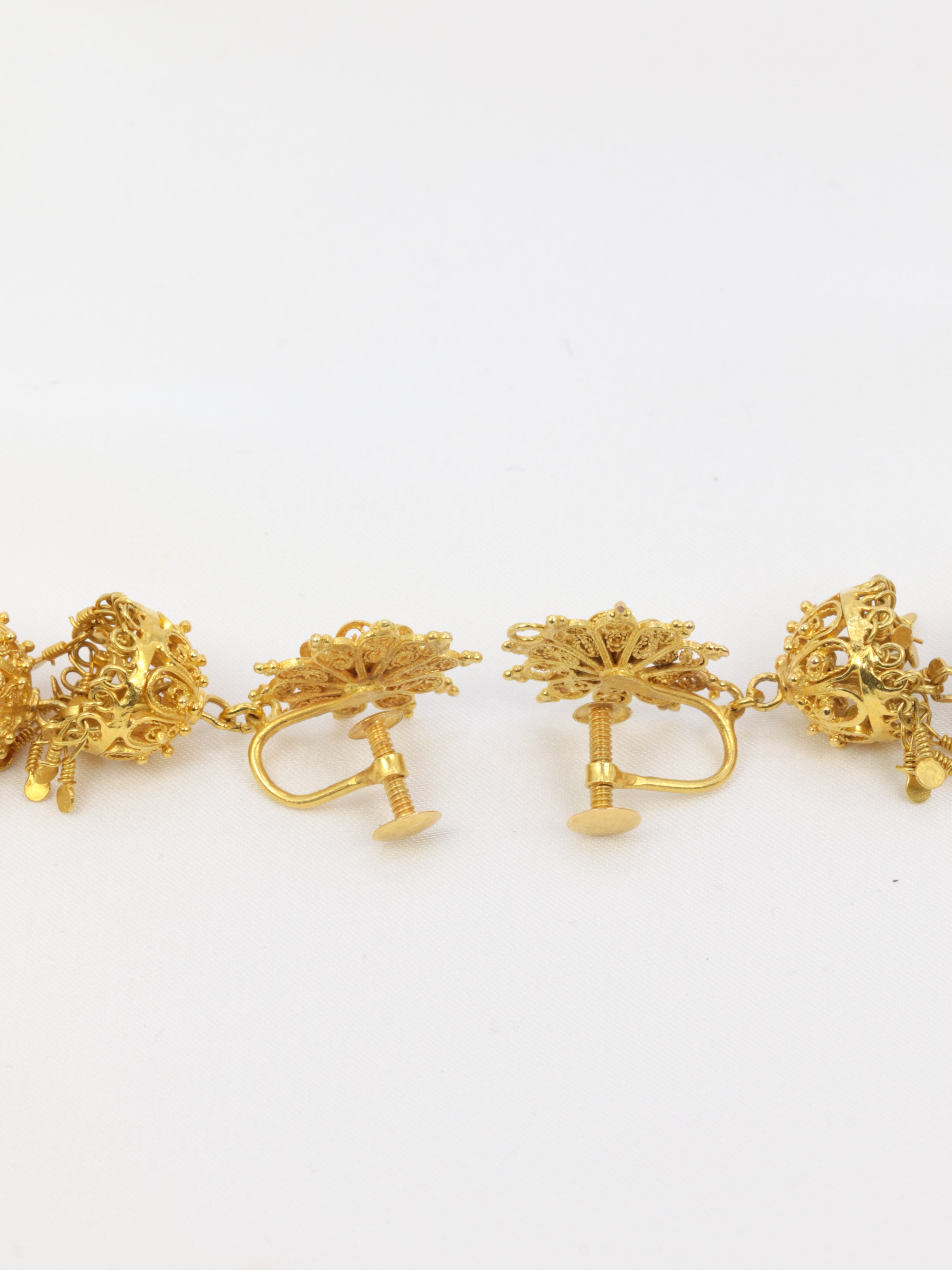 Old earrings composed of arabesques and gold tassels