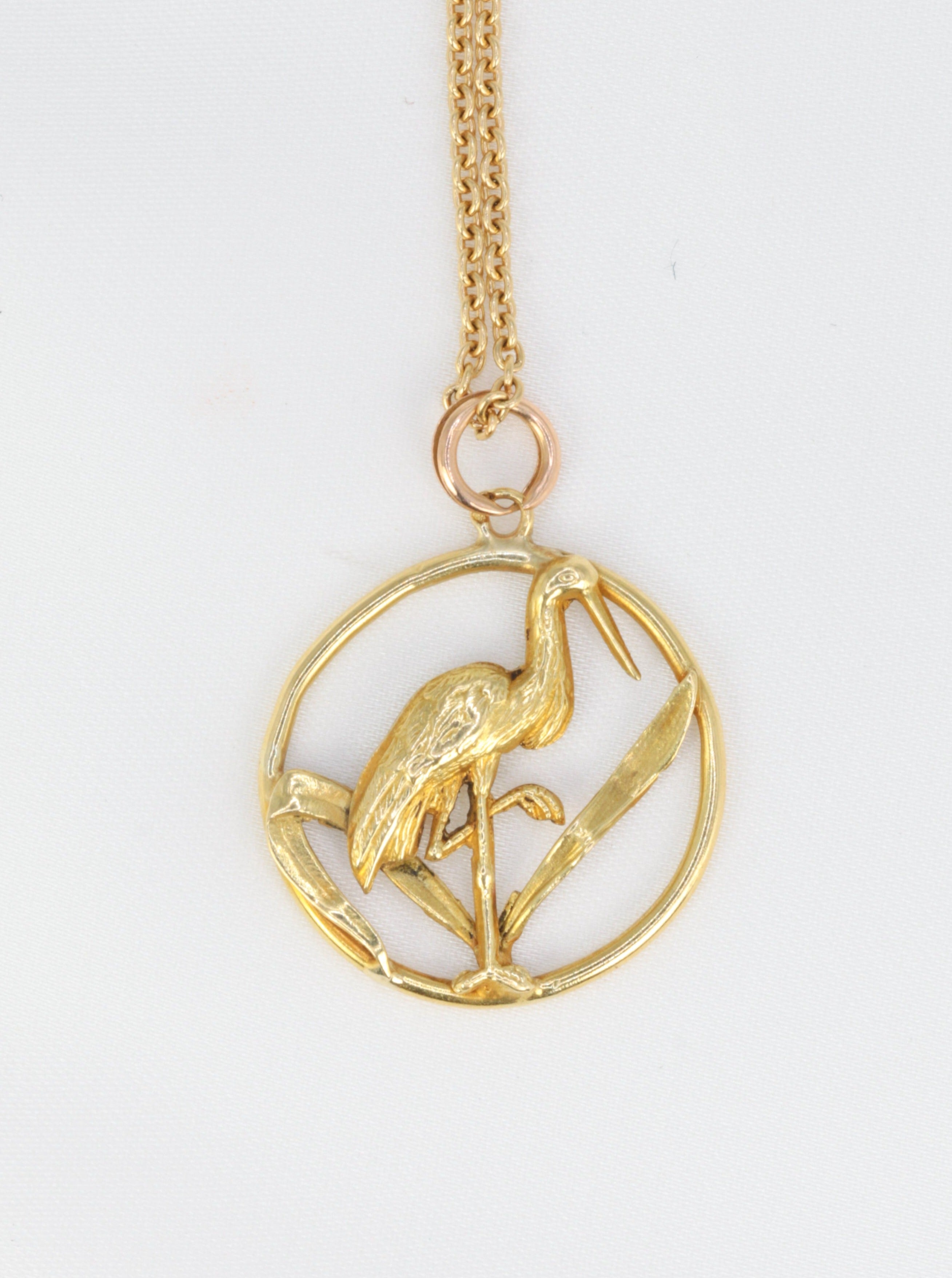 Old gold pendant depicting a stork