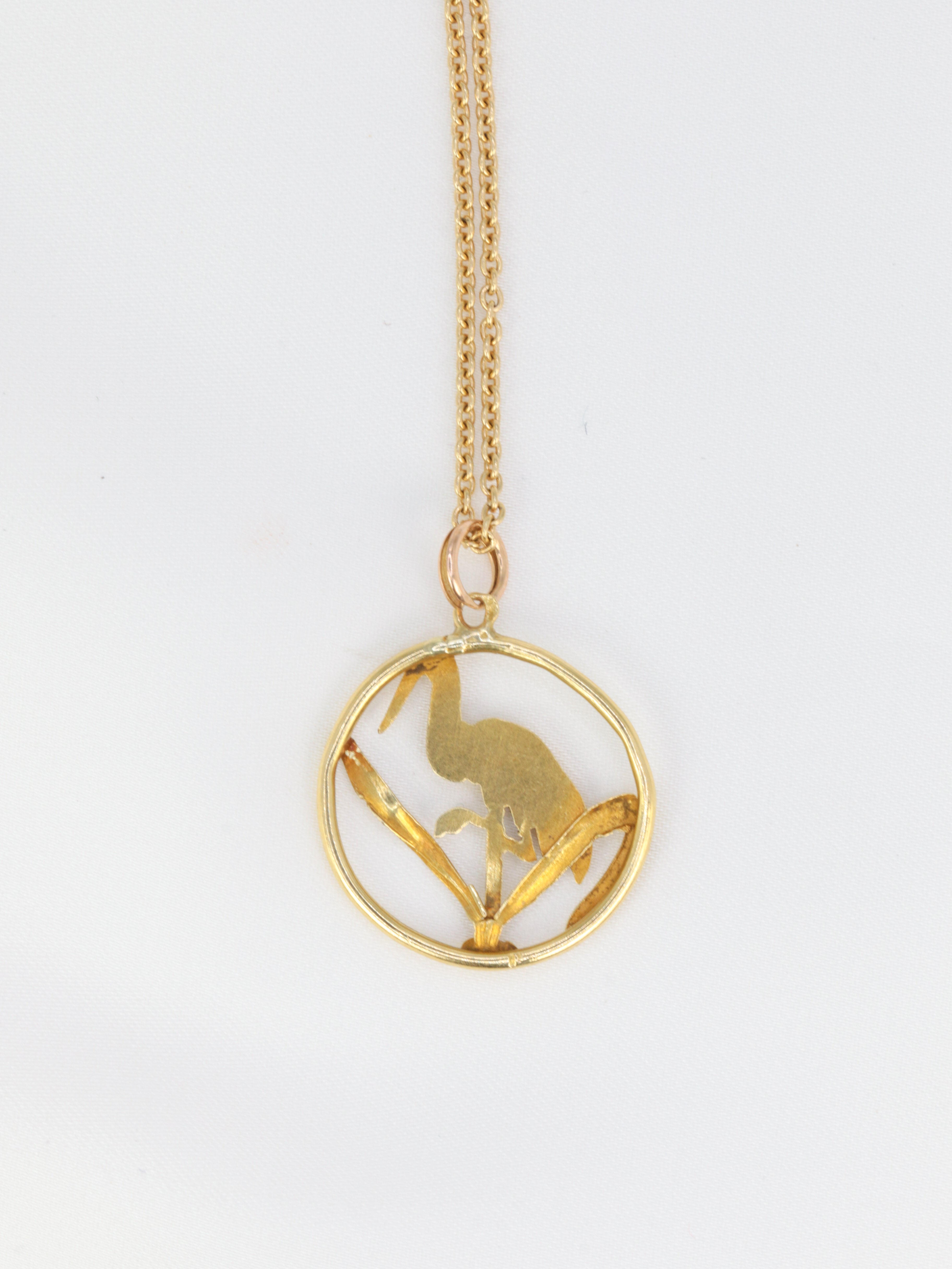 Old gold pendant depicting a stork