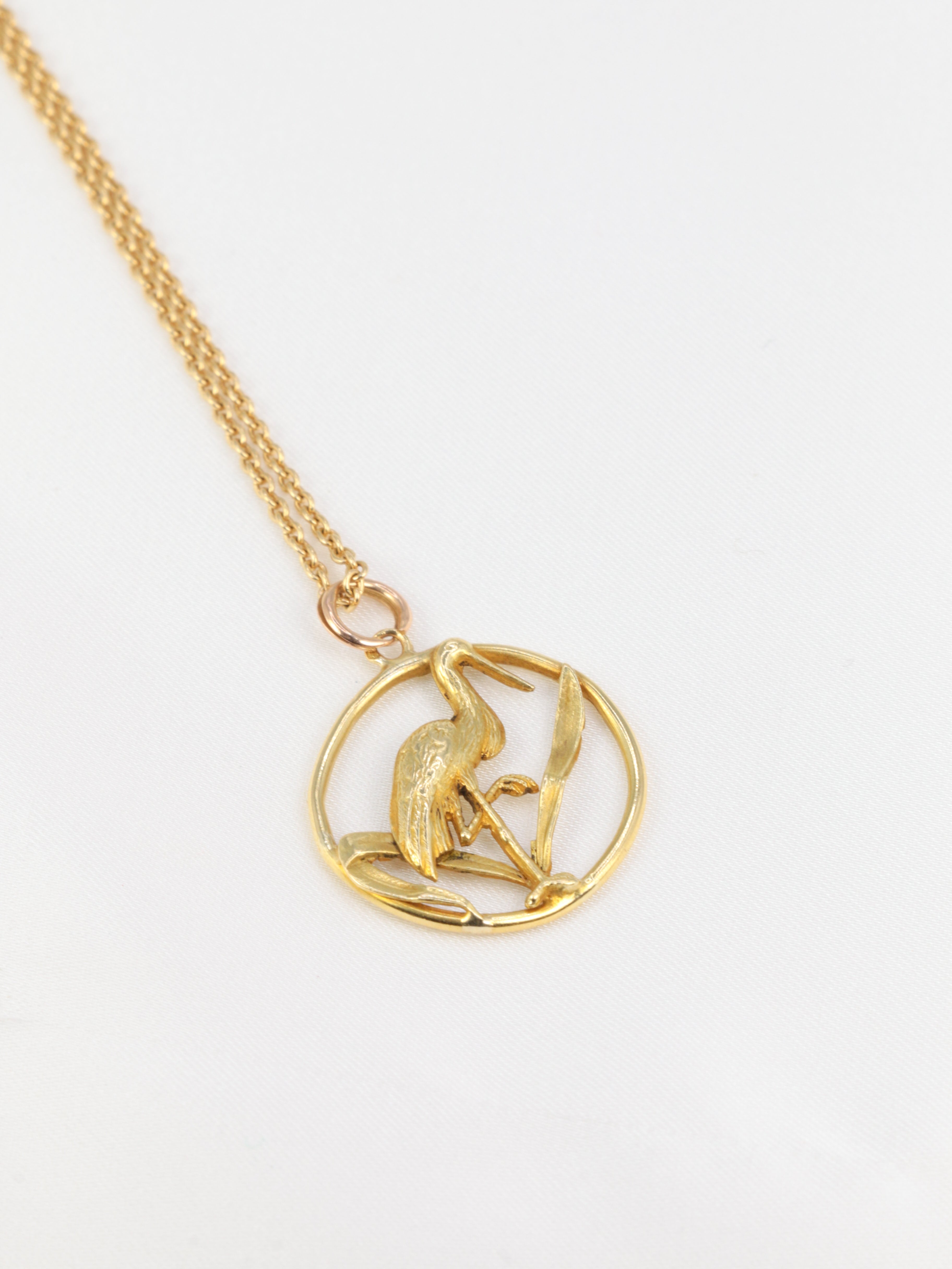 Old gold pendant depicting a stork