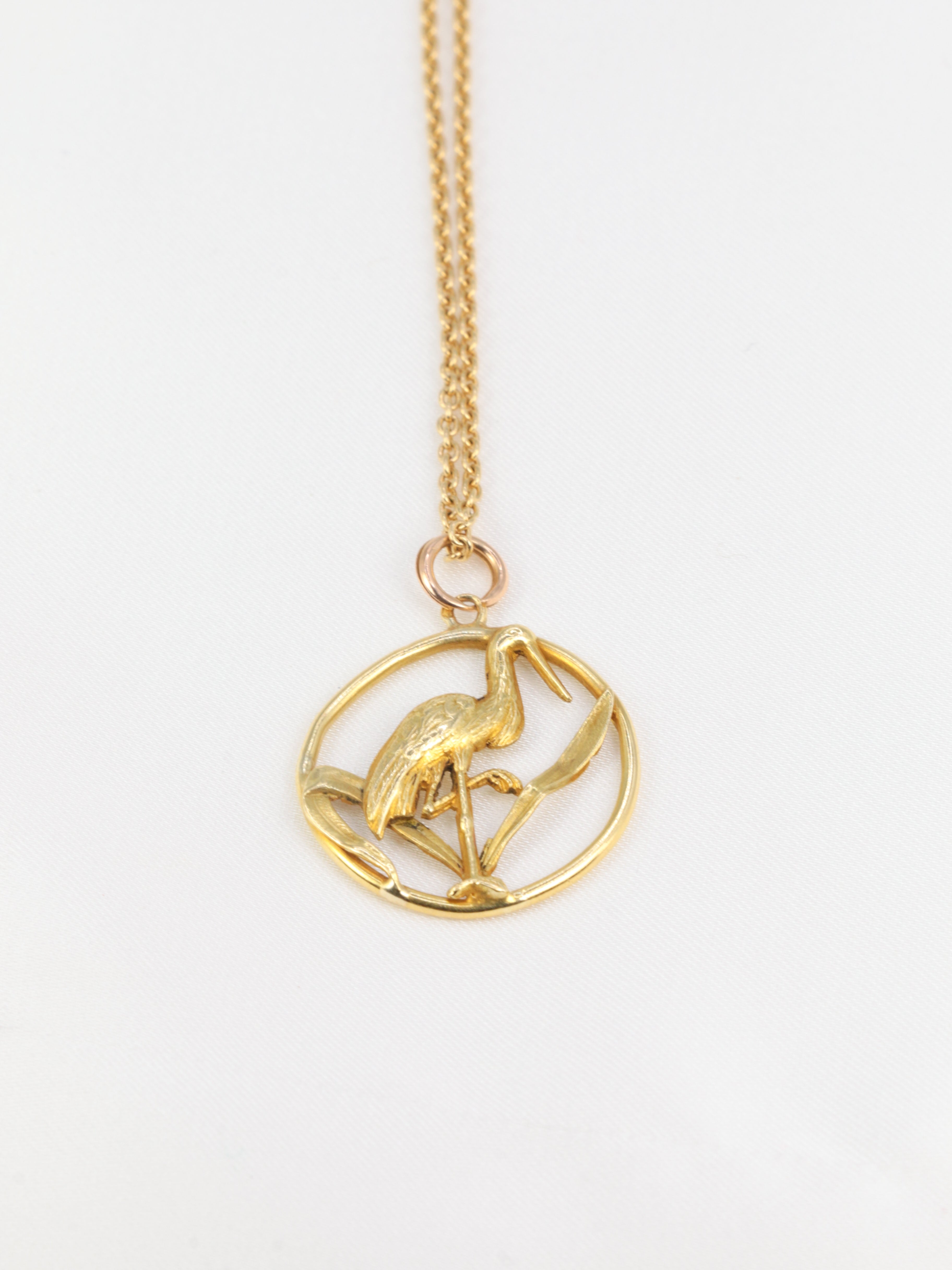 Old gold pendant depicting a stork