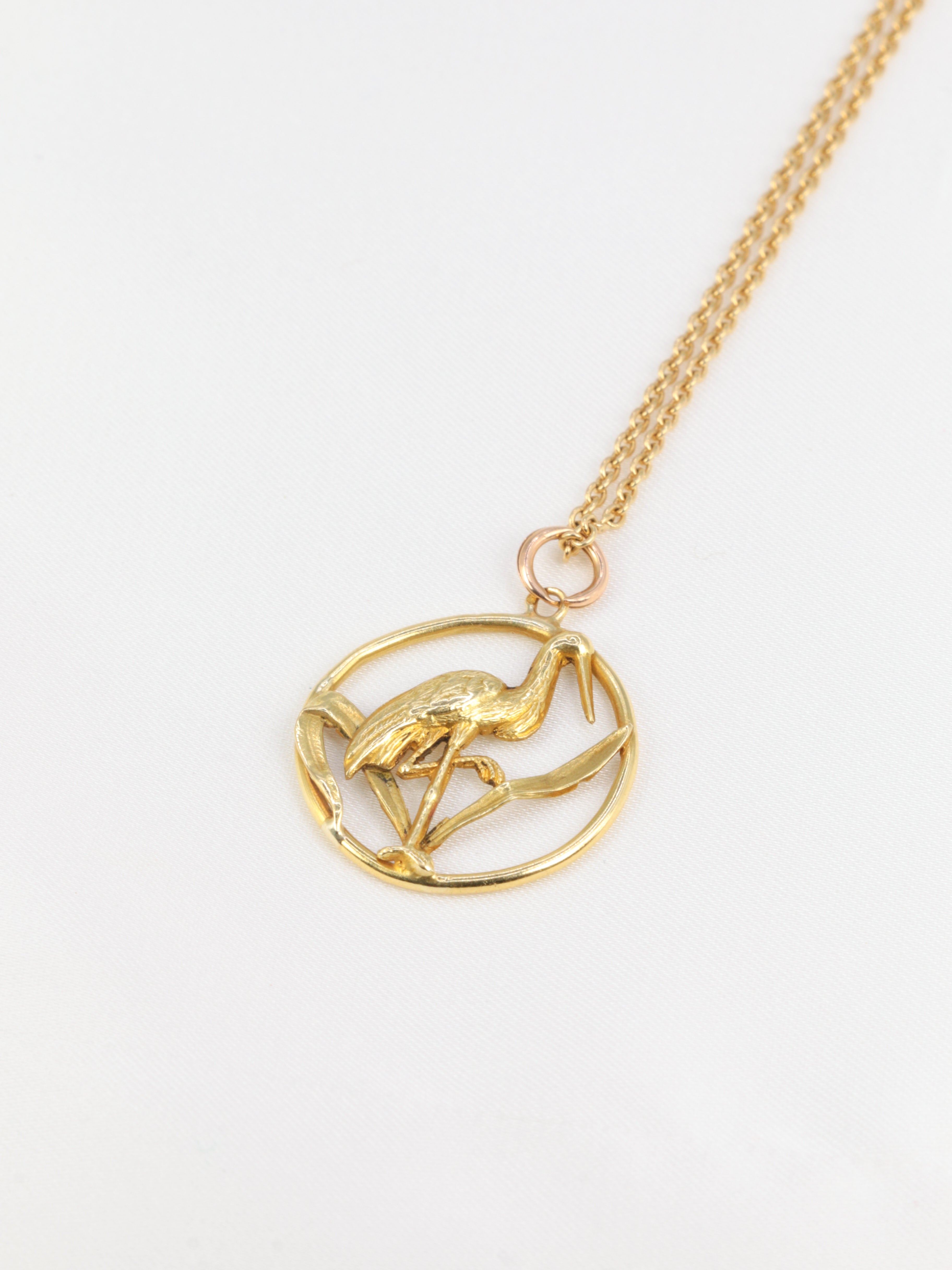 Old gold pendant depicting a stork