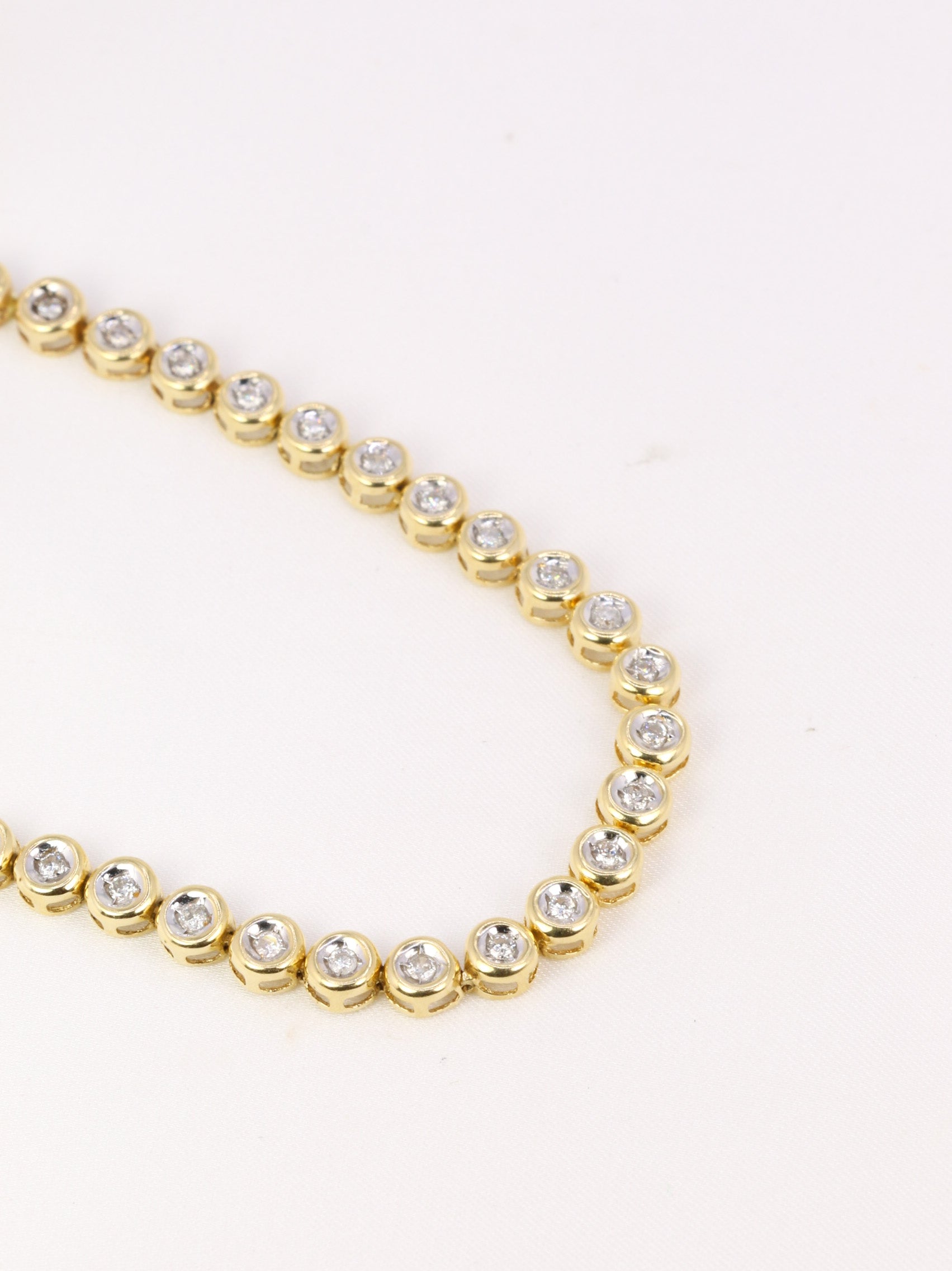 Vintage tennis bracelet in yellow gold and diamonds in bezel setting