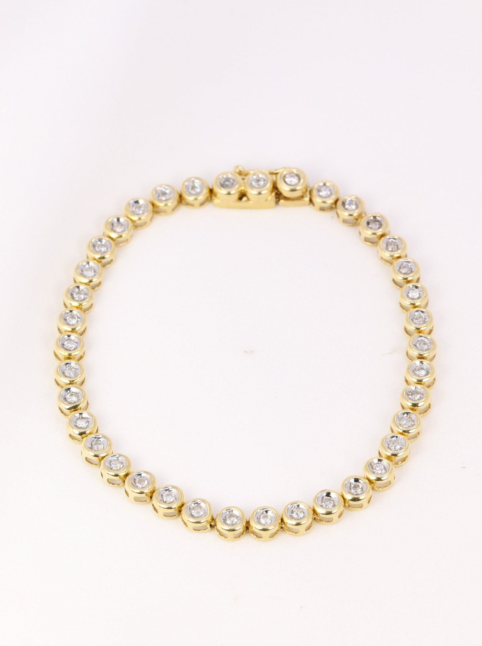 Vintage tennis bracelet in yellow gold and diamonds in bezel setting