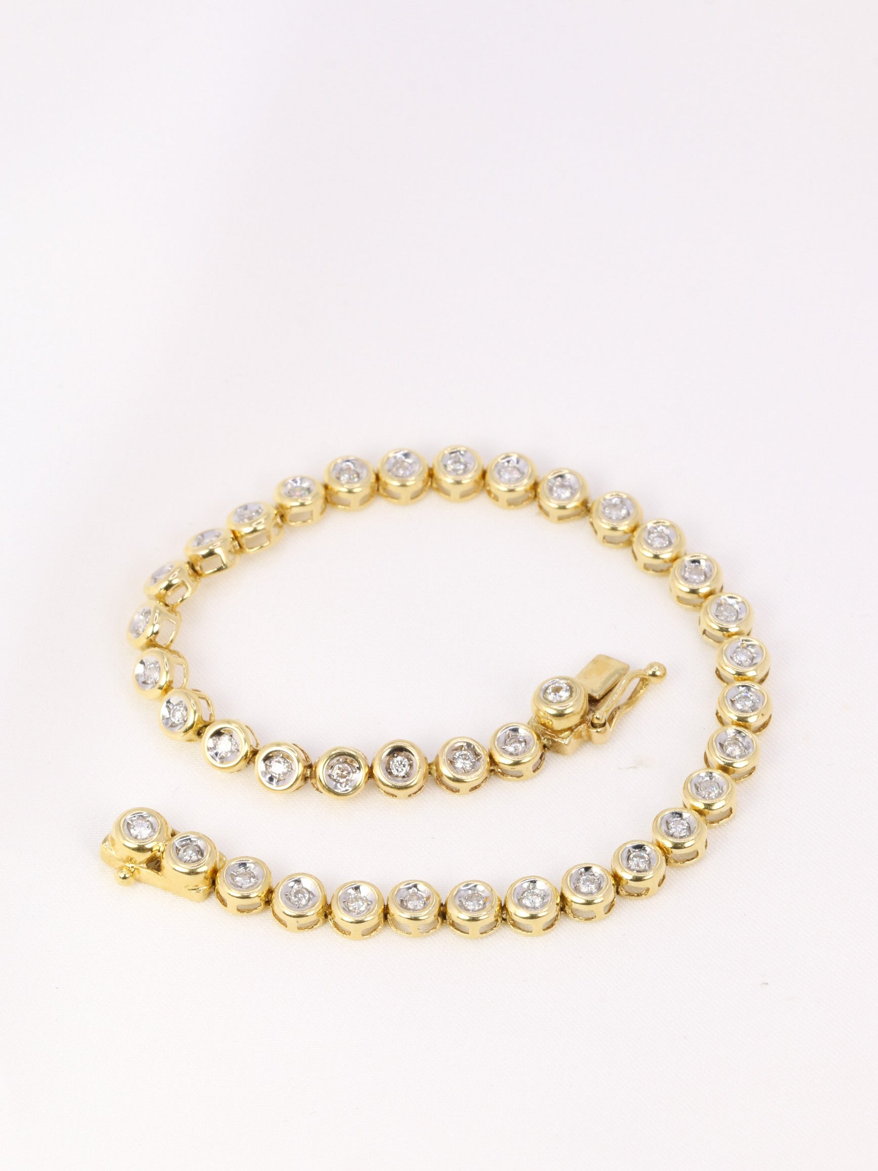 Vintage tennis bracelet in yellow gold and diamonds in bezel setting