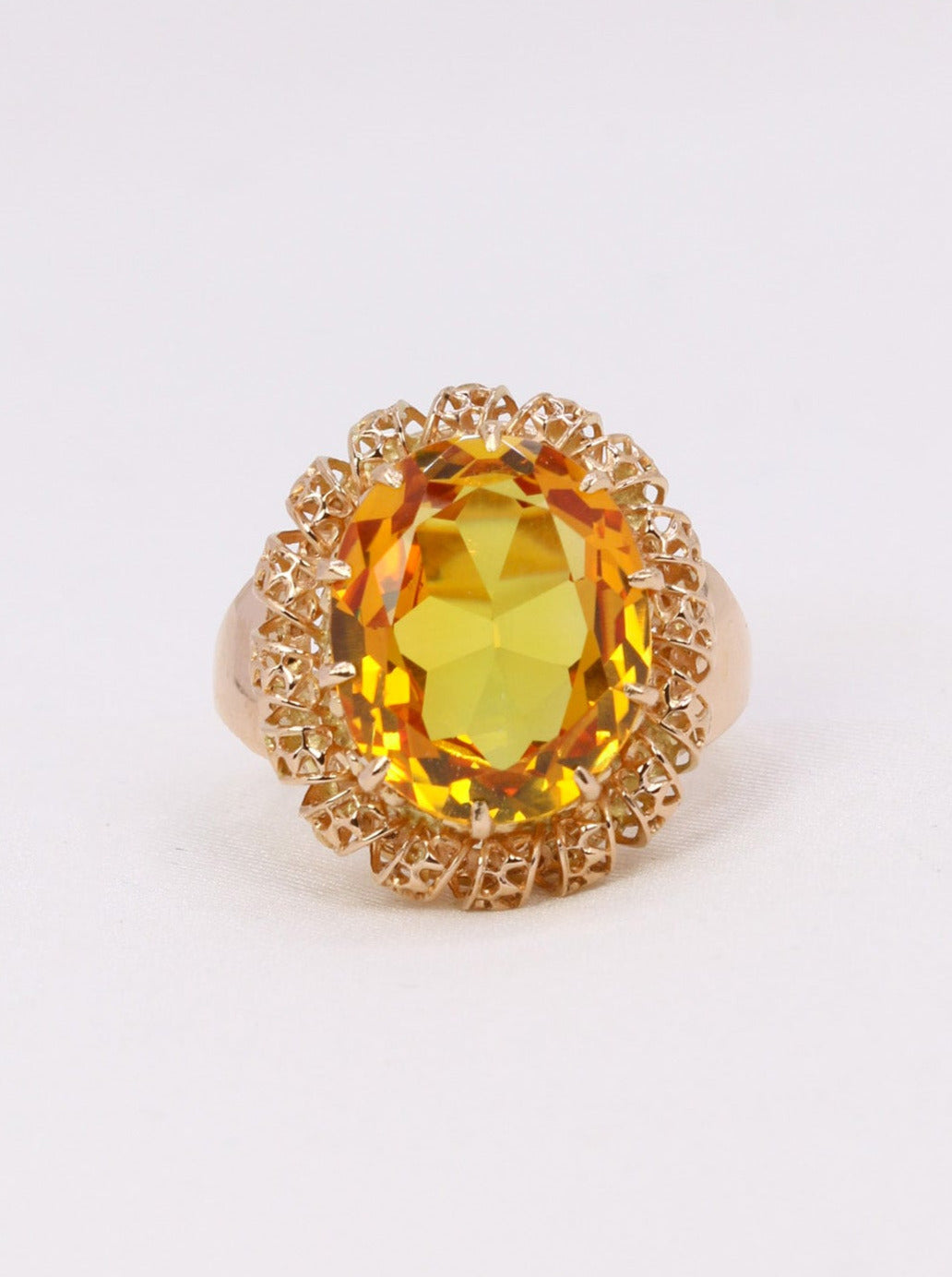 Bague cocktail en or 18k (750°/°°) sertie en son centre d'une citrine ovale pesant environ 5 carats entourée d'un motif en dentelle d'or finement ajouré. Travail français des années 1960. Poinçon tête d'aigle pour l'or 18k et trace de poinçon de fabricant ( O B un carré). Tour de doigt : 48. Poids brut : 5,36 grammes