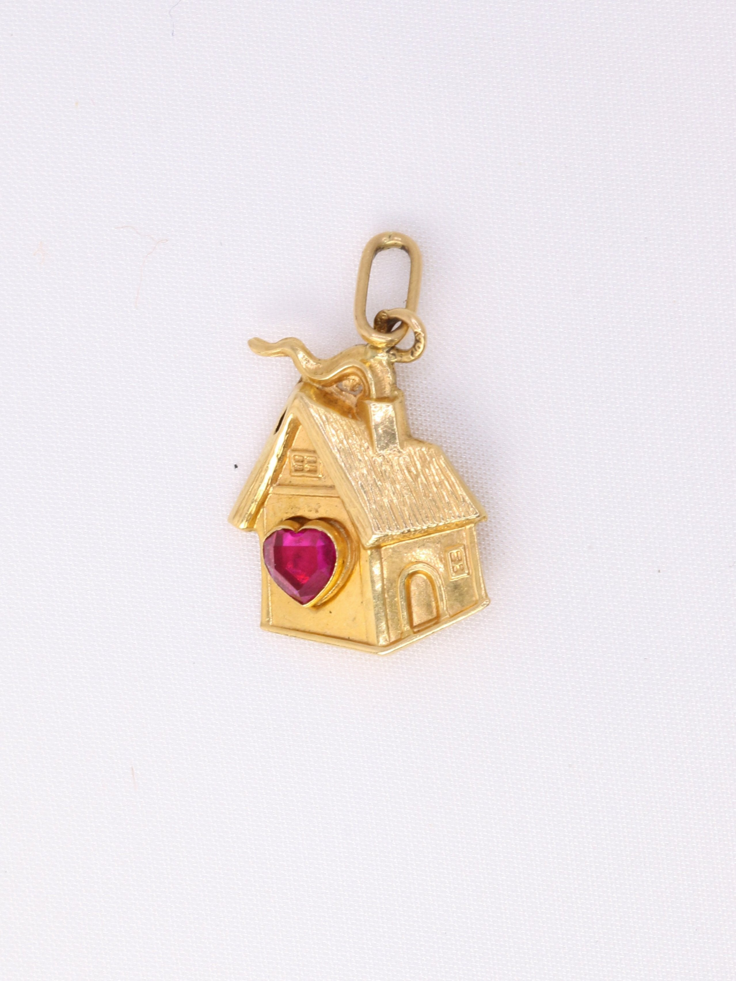 Charms vintage maison or jaune

Pendentif maison en or 18k (750°/°°) sertie d’un rubis synthétique en forme coeur. Travail français des années 1970. Présence du poinçon tête d’aigle pour l’or 18 carats et poinçon de fabricant.

Hauteur bélière incluse : 2,3 cm
Largeur : 1,3 cm
Poids net : 1,03 gramme