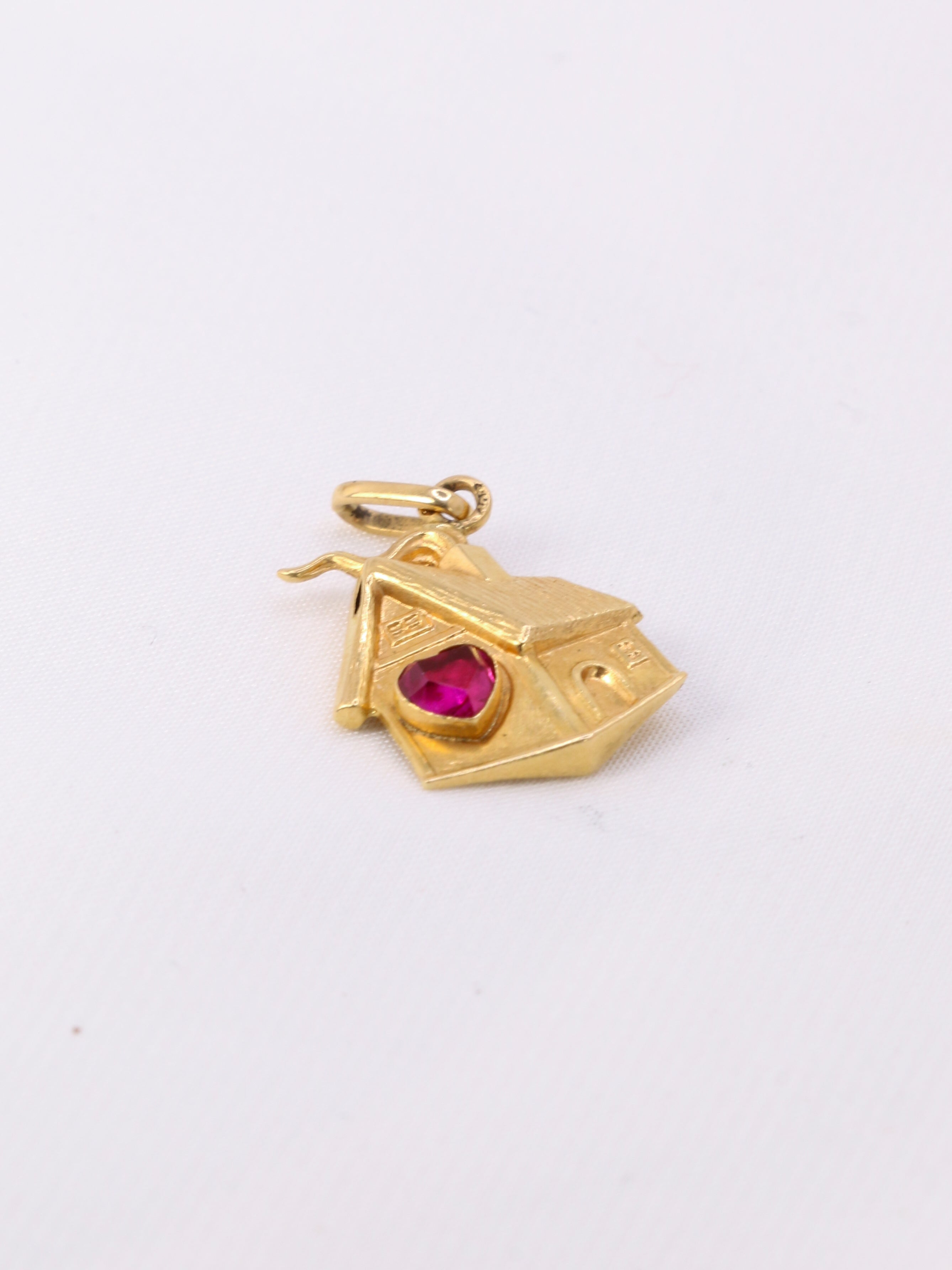 Charms vintage maison or jaune

Pendentif maison en or 18k (750°/°°) sertie d’un rubis synthétique en forme coeur. Travail français des années 1970. Présence du poinçon tête d’aigle pour l’or 18 carats et poinçon de fabricant.

Hauteur bélière incluse : 2,3 cm
Largeur : 1,3 cm
Poids net : 1,03 gramme