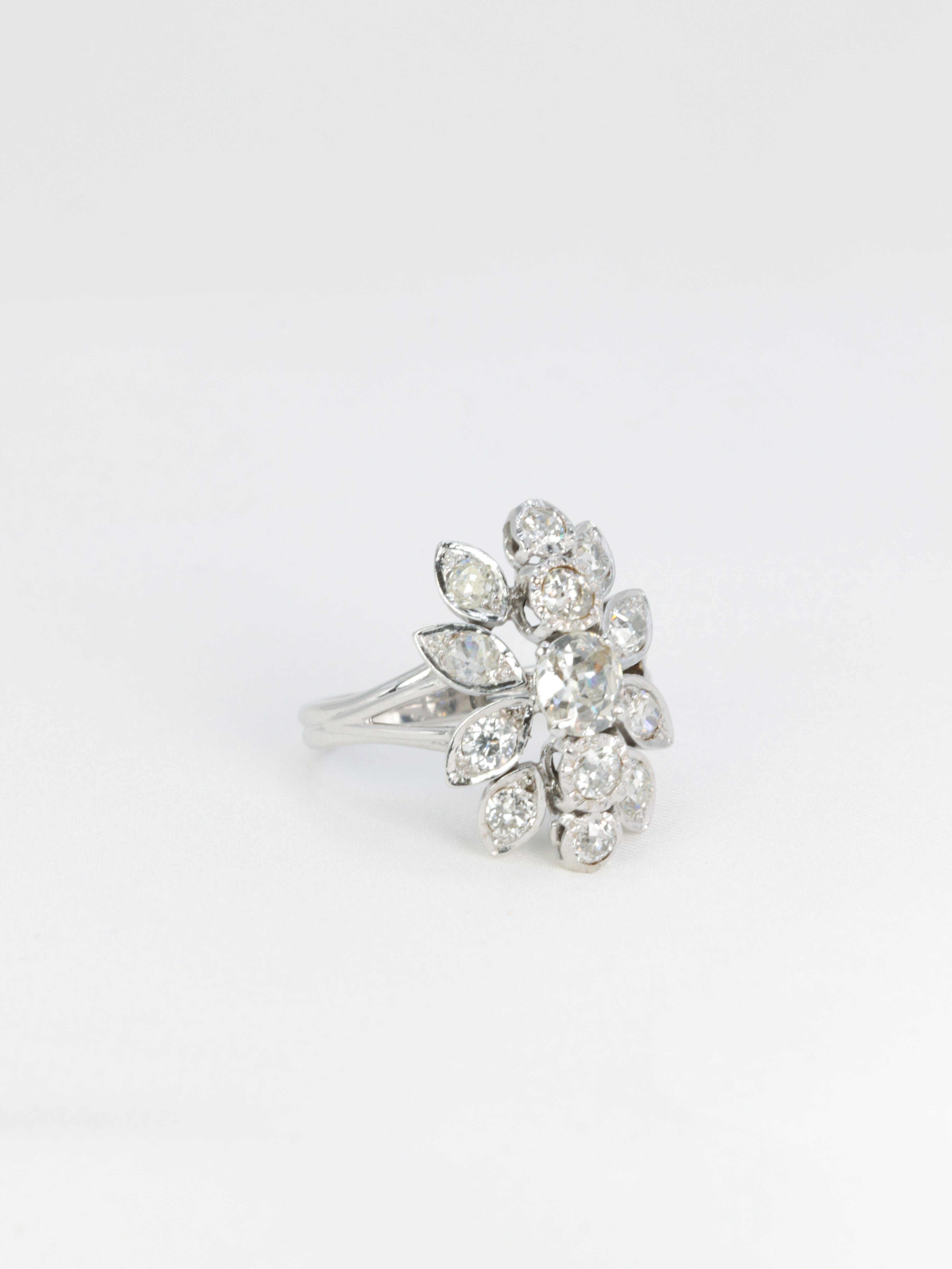 Antique flower ring in gold, platinum and diamonds featuring a floral motif