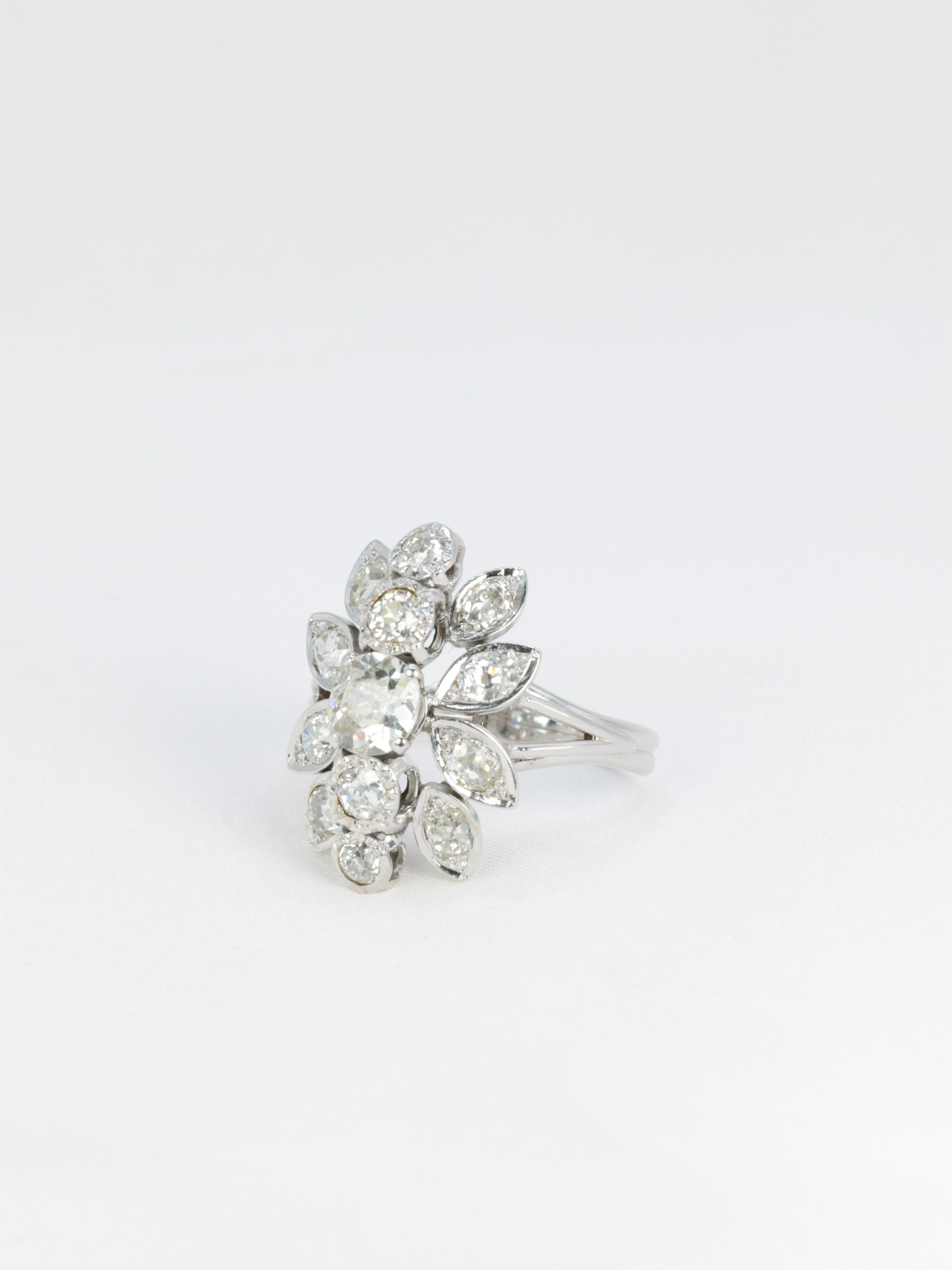 Antique flower ring in gold, platinum and diamonds featuring a floral motif