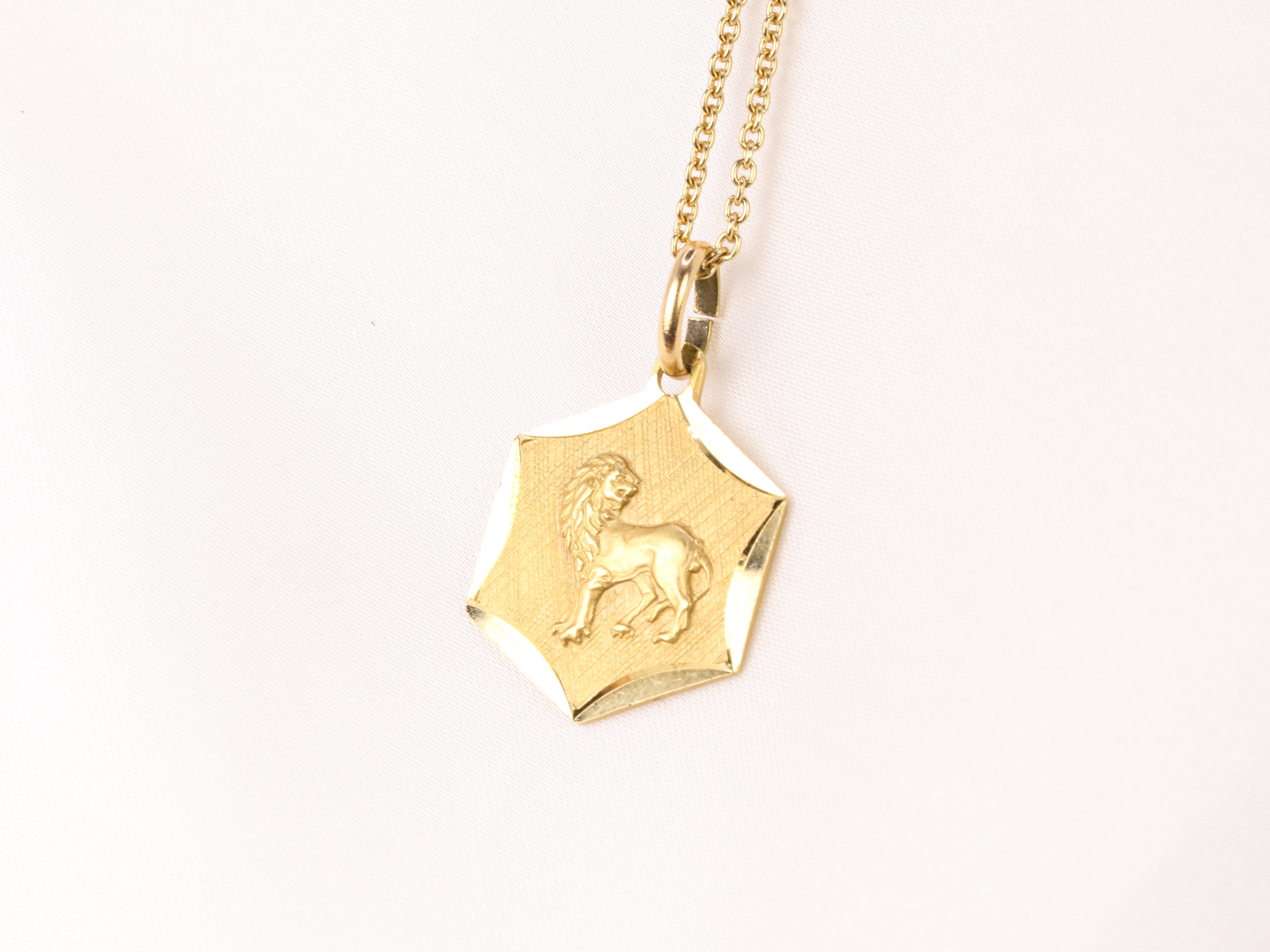 Vintage yellow gold medal featuring the zodiac sign of Leo