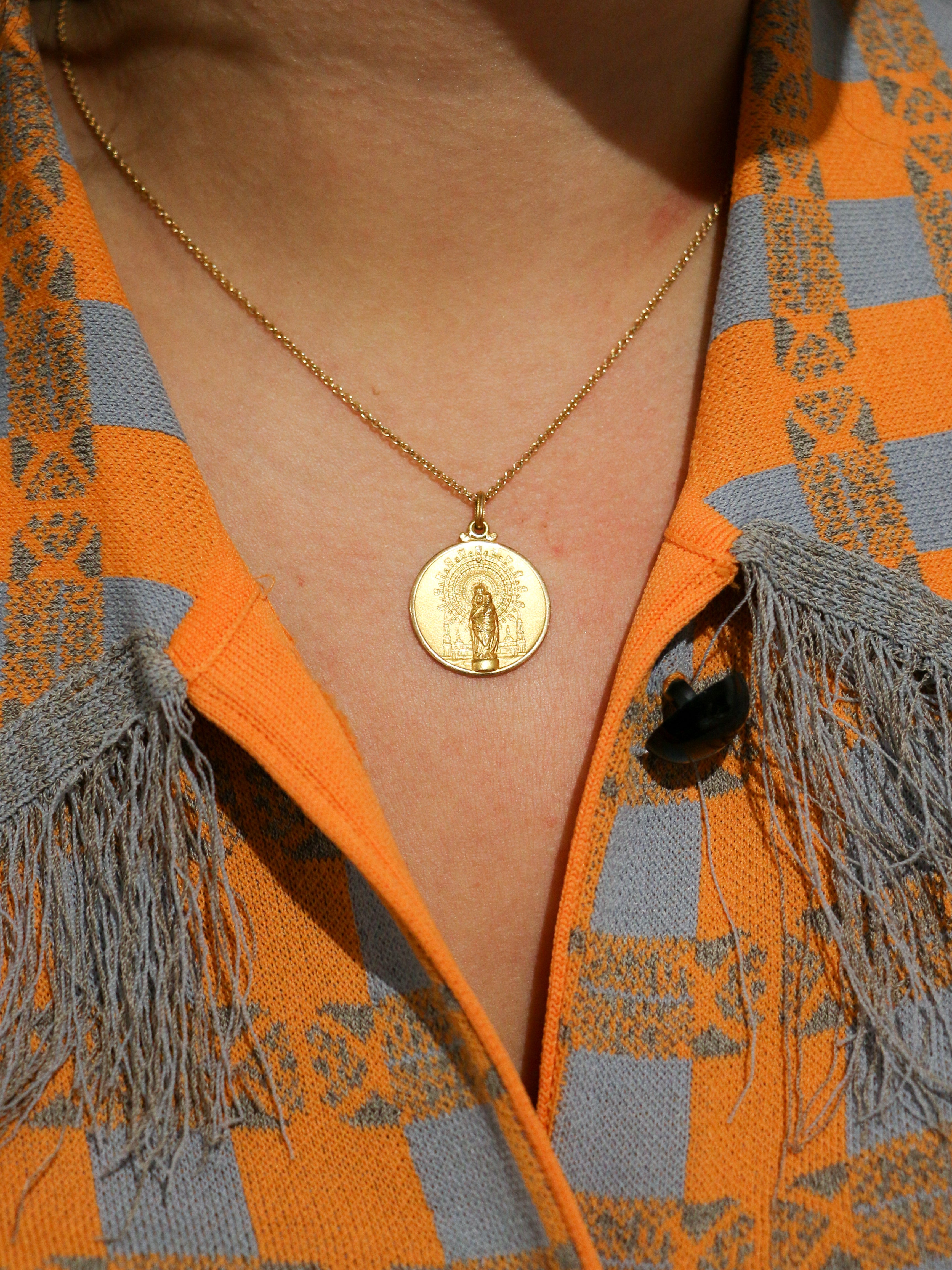 Vintage gold medal pendant depicting a virgin and child