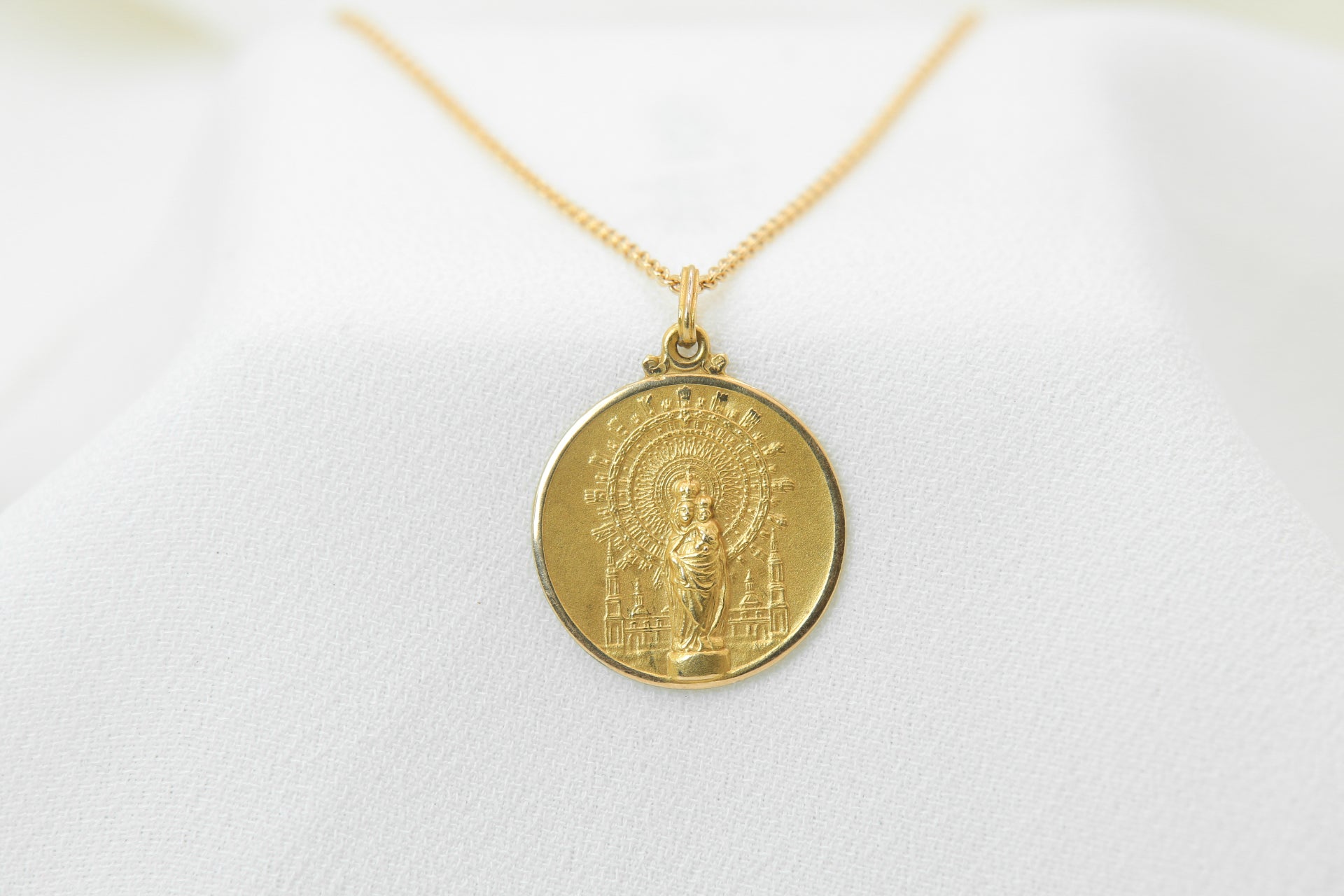 Vintage gold medal pendant depicting a virgin and child