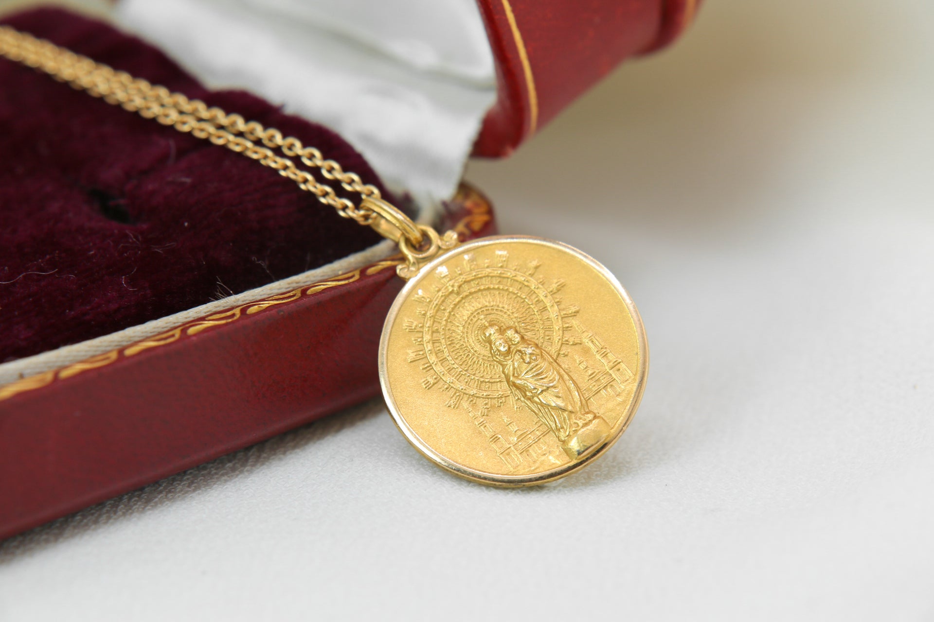 Vintage gold medal pendant depicting a virgin and child